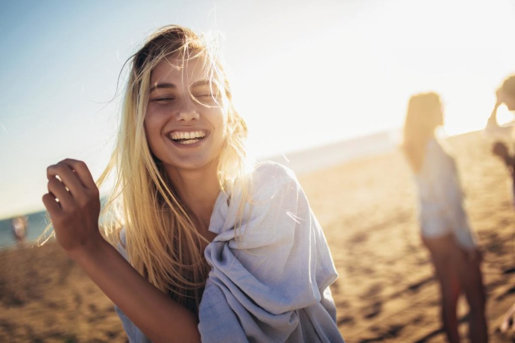 a person smiles on a beach