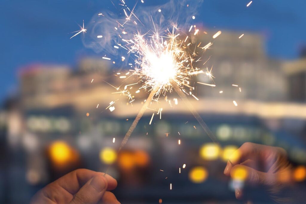 two sparklers are touched to symbolize getting sober in the new year