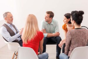 a group of people talk to a therapist